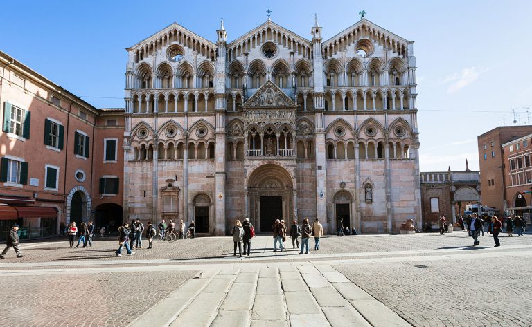 FERRARA, ITALY - NOVEMBER 6, 2012: Duomo and tourists on piazza Cattedrale in Ferrara city. Construction of present building began in the 12th century and the cathedral was consecrated in 1135