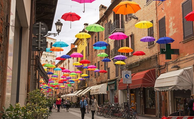 Ferrara, Italy - May 02, 2016: Colorful umbrellas hanging above street of Ferrara, Italy