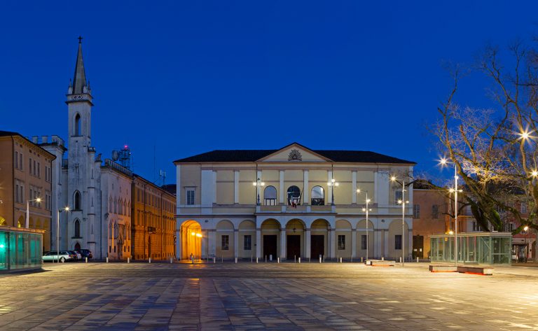 Reggio Emilia - Piazza della Vittoria, Teather Ariosto and Galleria Parmeggiani at dusk.
