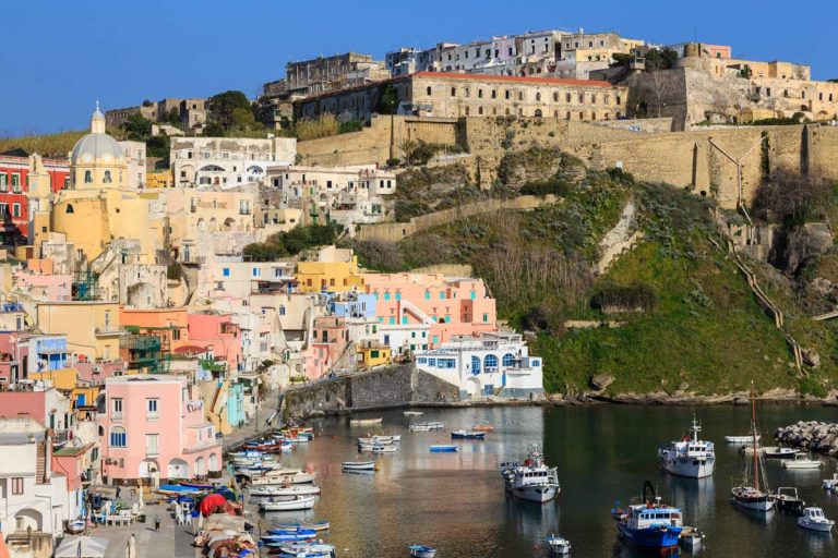Marina Corricella, Procida Island, Campania, Italy - 03 16 17: Elevated view of the famous fishing village overlooked by a walled old town on an Italian island in the Bay of Naples