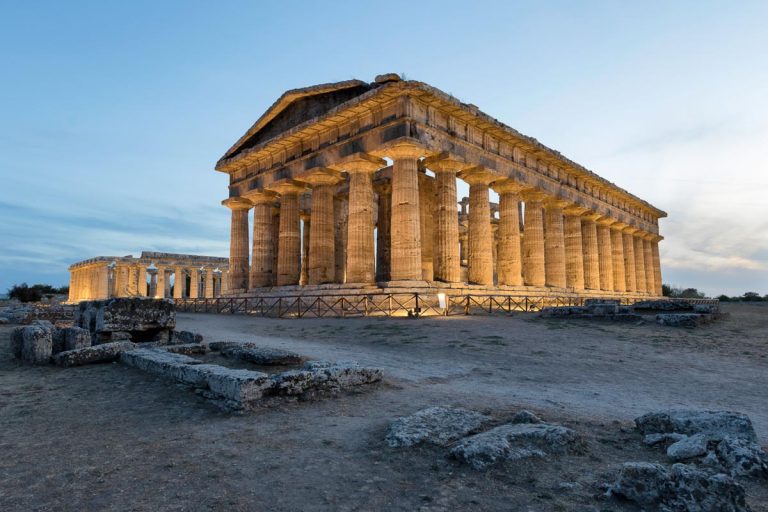 The Second Temple of Hera in Paestum, Southern Italy. The magnificent beauty of history framed with the technology of modern times. Isolated temple with a dramatic orange sky at sunset in the back