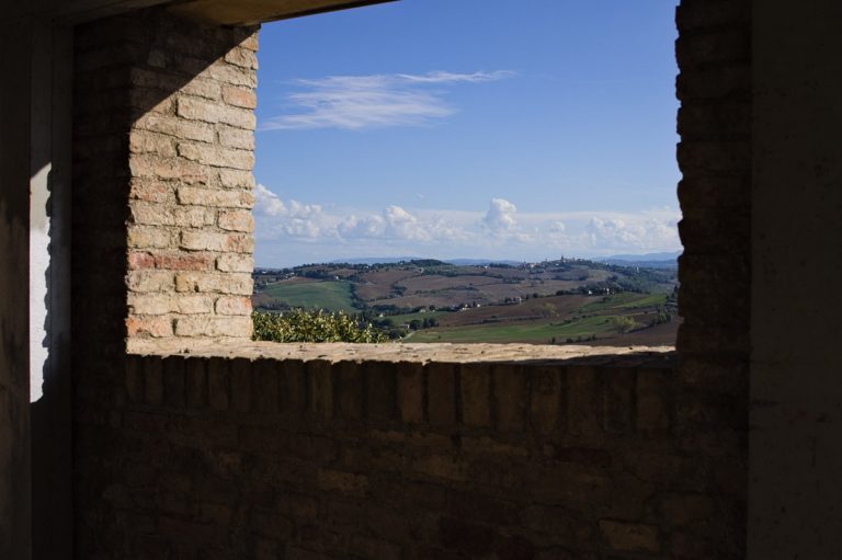 Beautiful landscape with italian hills seen through a medieval arch (Corinaldo, Marche, Italy, Europe)