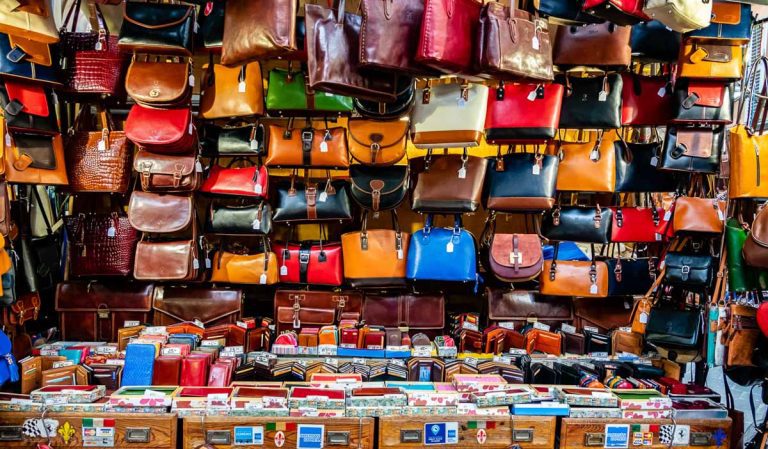 Florence, Italy - June 8, 2018: Florence is well known for its leather goods, including these colorful leather purses, handbags and wallets on display for sale at the outdoor Lorenzo Market.