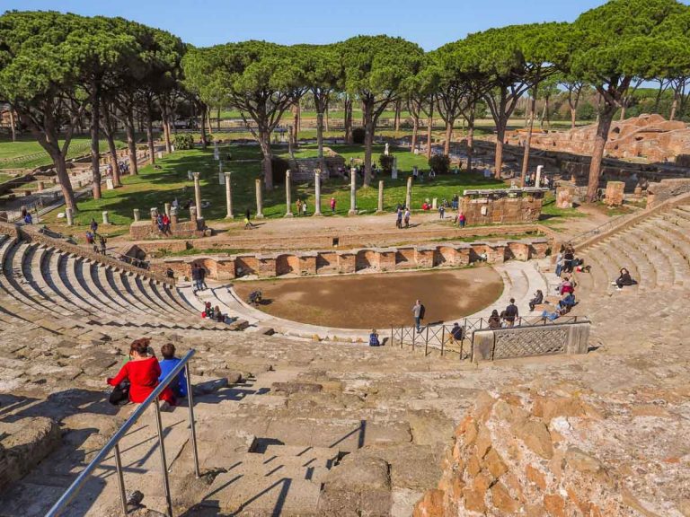 Ostia Antica / Italy - 03 03 2019: Ruins in the square Piazzale delle Corporazioni. Remains of orchestra and scaena of the theatre, columns, marble masks. Ostia Antica excavated park, open-air museum.