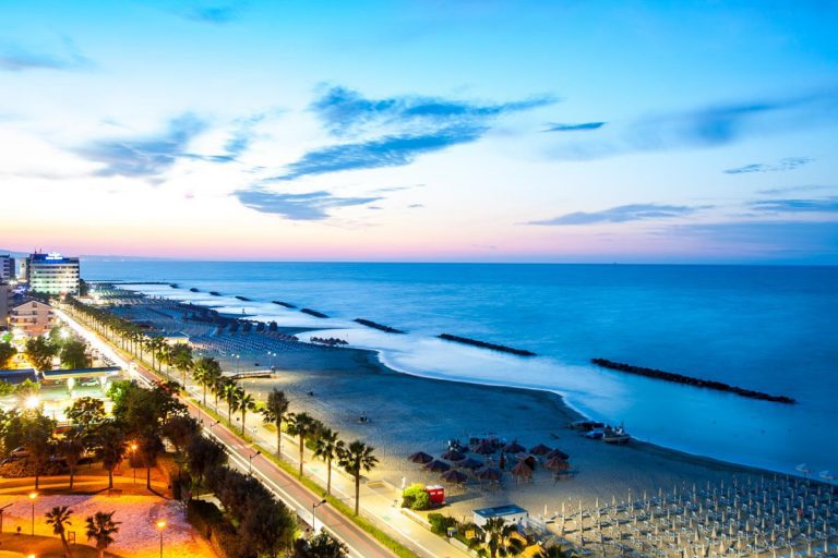 MONTESILVANO, ITALY. June 16, 2018: Evening panorama at sunset Montesilvano waterfront in the province of Pescara in Italy. Lights and beach in a famous Italian seaside resort. From above aerial photo