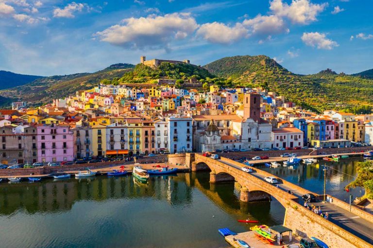 Aerial view of the beautiful village of Bosa with colored houses and a medieval castle. Bosa is located in the north-wesh of Sardinia, Italy. Aerial view of colorful houses in Bosa village, Sardegna.