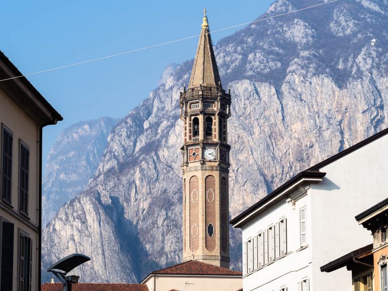 Travel to Italy - bell tower Campanile di San Nicolo and view of mount Monte San Martino in Lecco city, Lombardy