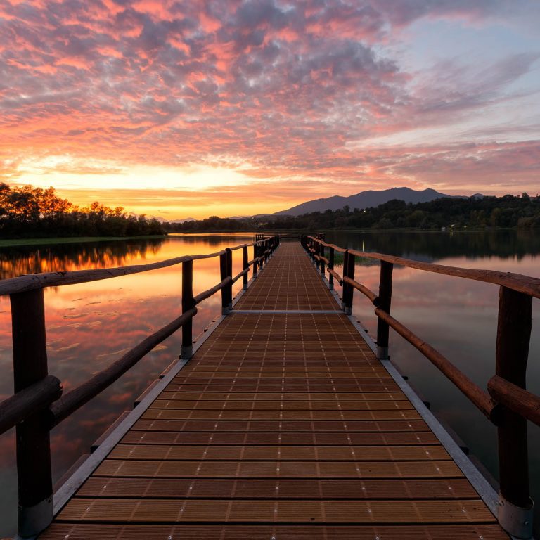 Wonderful sunset with a pier at Lago di Varese in Italy during summer