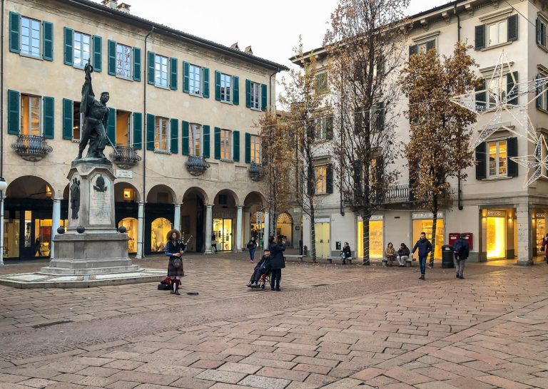 Varese, Italy - December 6, 2018: View of Podesta Square with monument to Giuseppe Garibaldi and street artist near, at afternoon in center of Varese, Italy
