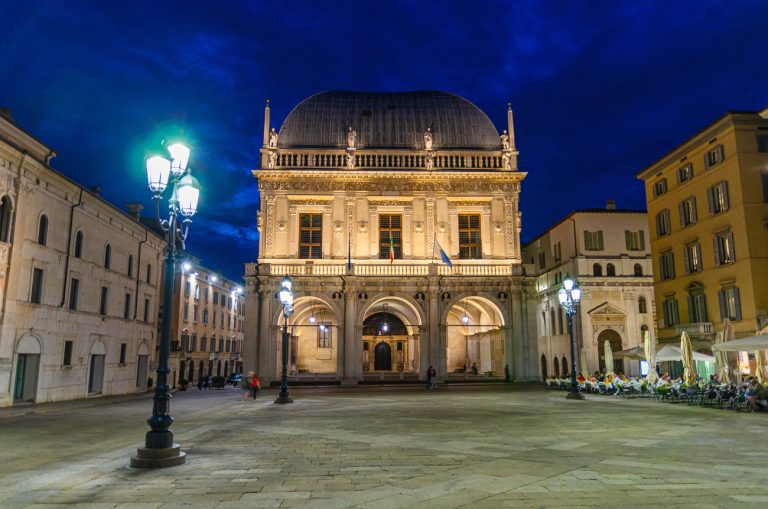 Palazzo della Loggia palace Town Hall Renaissance style building and street lights in Piazza della Loggia Square, Brescia city historical centre, night evening view, Lombardy, Northern Italy